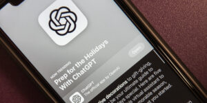 Close-up of a smartphone screen showing the ChatGPT app icon (intertwined loops) on a feed with article text nearby.