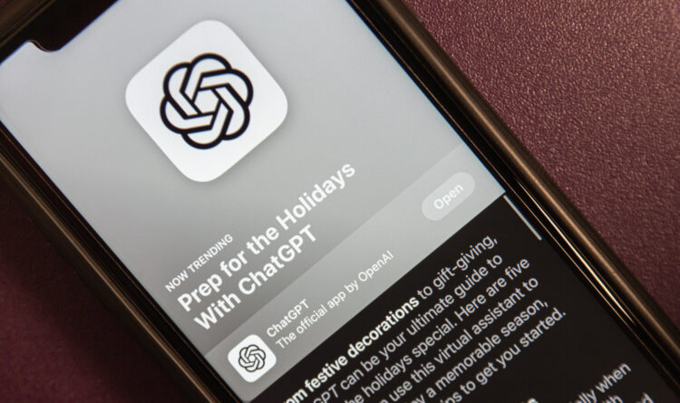 Paid ads on ChatGPT - Close-up of a smartphone screen showing the ChatGPT app icon (intertwined loops) on a feed with article text nearby.